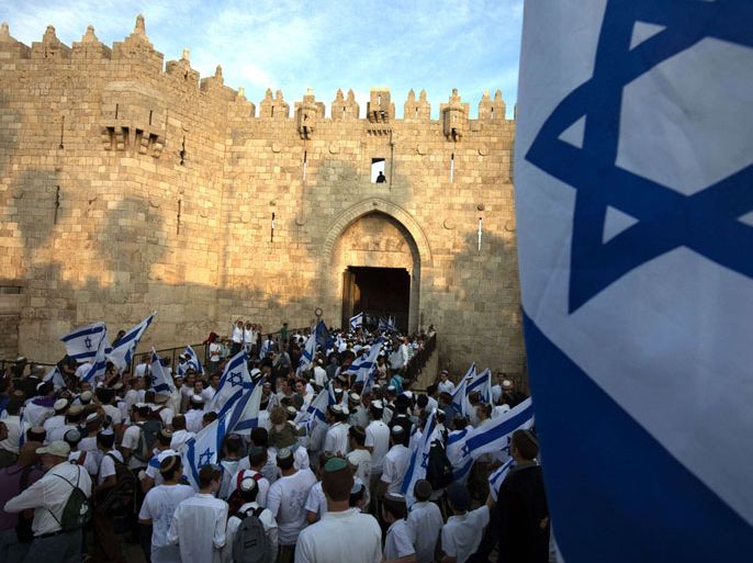 Israelis dance with their national flags at the Damascus Gate which leads into the Old City of Jeruslaem as thousands of Israeli march into the old city on May 20, 2012, to celebrate Jerusalem Day when the Jewish state captured the Arab eastern sector 45 years ago during the Six-Day War. AFP PHOTO/MENAHEM KAHANA
