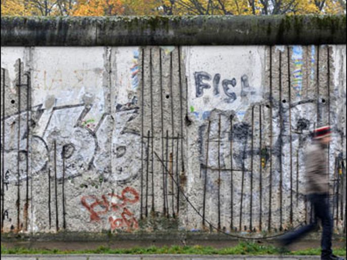 f/a youth walks past one of the few remaining segments of the berlin wall (1961-1989) on bernauer strasse, in berlin on november 6, 2008 (الفرنسية)