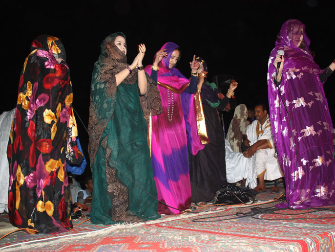 الطاهرة بنت النانة منظمة الحفل (يمين) مع فنانات أخريات يغنين في الحفل (الجزيرة)