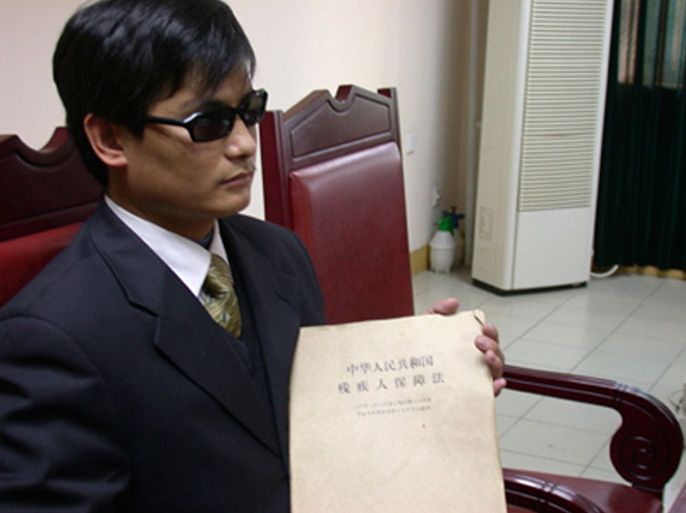 Blind legal activist Chen Guangcheng holds a document that reads: "Law of the People's Republic of China on the Protection of Disabled Persons", in this undated handout. U.S. Secretary of State Hillary Clinton arrived in China on Wednesday for top-level talks that risk being upstaged by the fate of Chen,