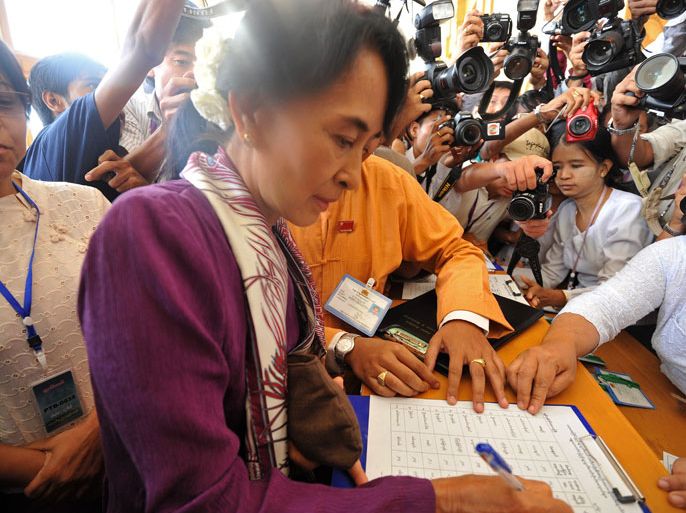 Myanmar opposition leader Aung San Suu Kyi signs the attendance sheet as she arrives at the lower house of parliament to read her parliamentary oath during a session in Naypyidaw on May 2, 2012