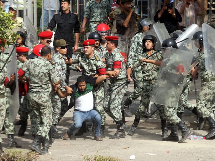 epa03206109 An Egyptian protester is taken away by Egyptian security forces, during a sit-in at Abbassiya square, near the Defense Ministry in Cairo, Egypt, 04 May 2012. Protesters clashed for the second time in two days after marches converged at the Defense Ministry. On 02 May 2012, clashes left nine people dead after unknown assailants attacked protesters according to the Egyptian military council. EPA