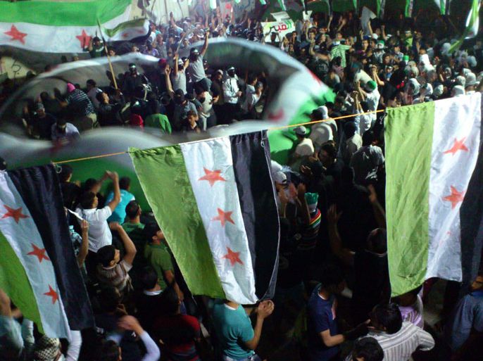 A handout image released by the Syrian opposition's Shaam News Network shows Syrians waving pre-Baath flags adopted by the revolution during an anti-regime demonstration in Kfar Sousa on June 7 , 2012.