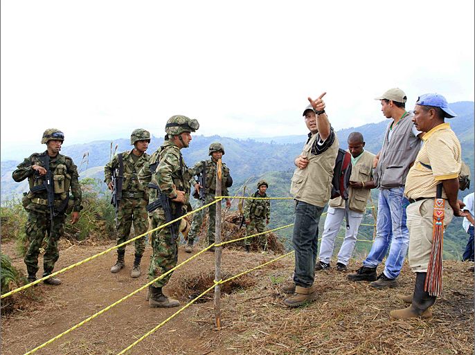 Peasants and members from a human rights organization speak with soldiers in a rural area of Miranda, Cauca June 28, 2012. Peasants and the indigenous community asked the army to remove a military base that was built on their territory, which endangered their lives as a result of clashes with guerrillas of the Revolutionary Armed Forces of Colombia (FARC). REUTERS/Jaime Saldarriaga (COLOMBIA - Tags: CIVIL UNREST MILITARY POLITICS)