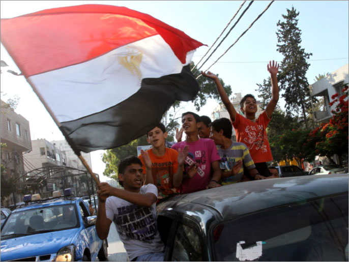 ‪غزي يحمل علم مصر في مسيرة سيارات عفوية وسط مدينة غزة‬ غزي يحمل علم مصر في مسيرة سيارات عفوية وسط مدينة غزة