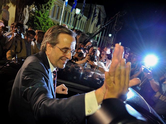 New Democracy party leader, Antonis Samaras (Bottom C), waves to supporters as he leaves at the end of a press conference after his party came first in the national Greek's election, at the Zappion Hall in central Athens, on June 17, 2012. Greece's two main pro-bailout parties clinched enough votes to form