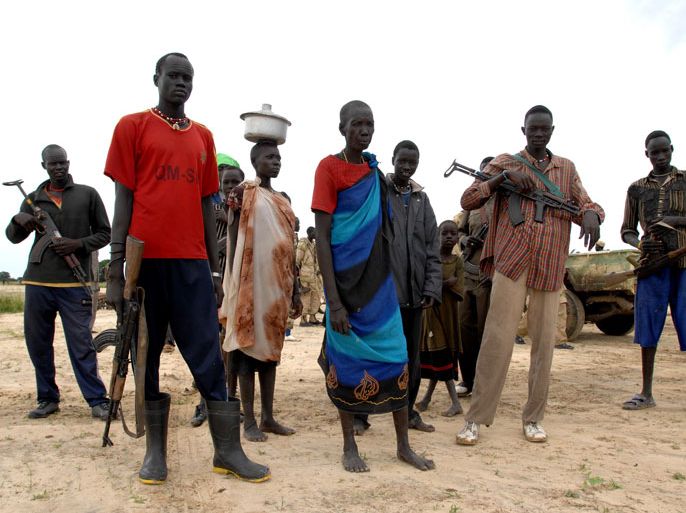 epa01871284 A handout picture released by United Nations Missions in Sudan made available on 23 September shows armed residents of Duk Padiet standing near the airstrip in Duk Padiet, Sudan on 22 September 2009, two days after the village was attacked by the neighboring Lou Nuer tribe reportedly killing 76 people. Southern Sudan has seen a pattern of escalating violence since the beginning of the year which has killed more than 2,000