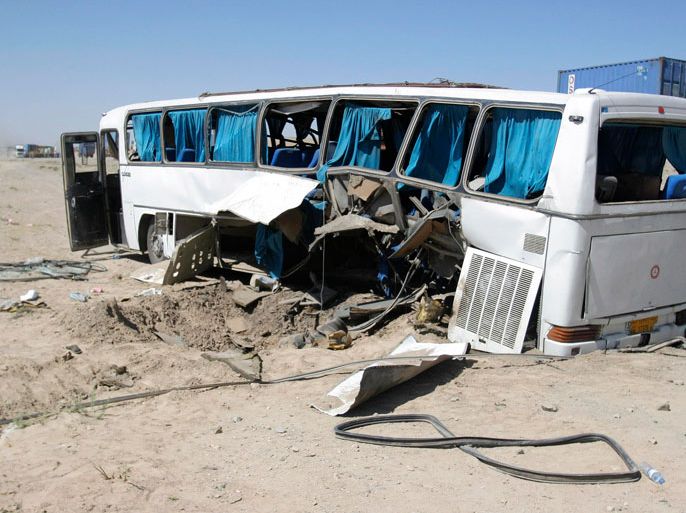 The wreckage of a bus that was damaged in a roadside bomb blast sits beside a road in Ghazni, July 1, 2012
