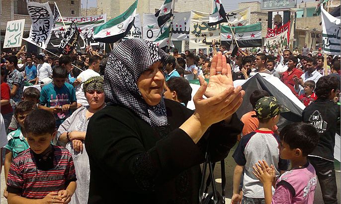A woman claps her hands as demonstrators protest against Syria's President Bashar al-Assad at Binsh near Idlib July 6, 2012. REUTERS/Shaam News Network/Handout (SYRIA - Tags: POLITICS CIVIL UNREST) FOR EDITORIAL USE ONLY. NOT FOR SALE FOR MARKETING OR ADVERTISING CAMPAIGNS. THIS IMAGE HAS BEEN SUPPLIED BY A THIRD PARTY. IT IS DISTRIBUTED, EXACTLY AS RECEIVED BY REUTERS, AS A SERVICE TO CLIENTS