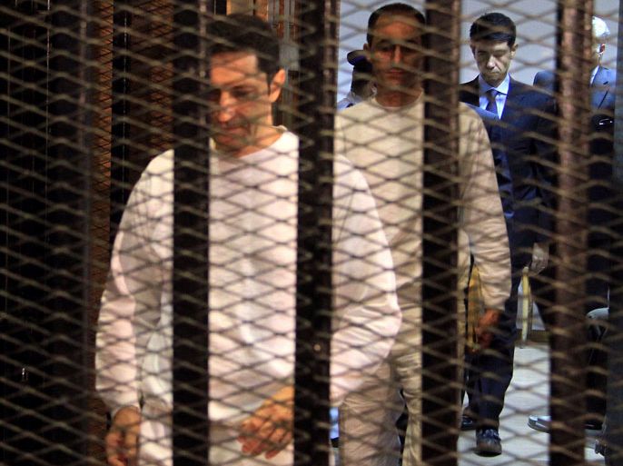 EGYPT : Gamal (back) and Alaa Mubarak, sons of ousted president Hosni Mubarak, arrive to attend their trial in the police academy in the outskirts of Cairo on July 9, 2012. Alaa and Gamal Mubarak appeared in court to face a new corruption trial, after the two were acquitted in another case