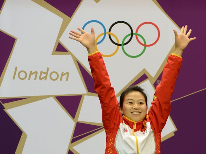 China's Gold medalist Yi Siling celebrates on the podium after winning the 10m air rifle women's final at the London 2012 Olympic Games at the Royal Artillery Barracks in London on July 28, 2012. AFP PHOTO/ KHALED DESOUKI