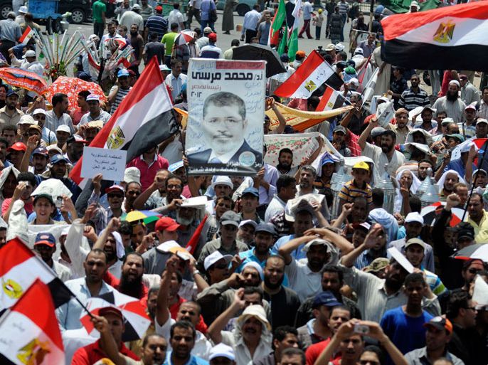 EGYPT : Egyptian demonstrators show their support for President Mohamed Morsi during a protest in Cairo'sTahrir Square on July 13, 2012. Morsi will respect a court ruling overturning his decree for the dissolved Islamist-dominated parliament to convene, his office said amid a power struggle with the military. AFP PHOTO/MOAHHMED HOSSAM