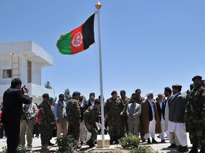 AFGHANISTAN : Afghanistan National Army (ANA) soldiers raise their national flag during a transition ceremony from French soldiers in Mahmud Raqi, Kapisa Province on July 4, 2012. The French military July 4 handed over a key Afghan province to local forces, completing an important stage in France's accelerated withdrawal from the war-torn country. The province of Kapisa was the last area of Afghanistan under the control of French troops, the bulk of whom are due to leave by the end of 2012, two years earlier
