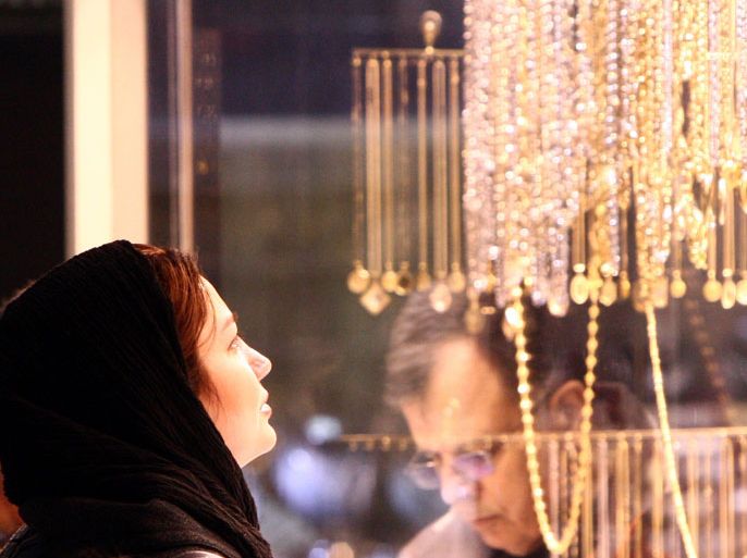 An Iranian woman window shopping in front of a jewelry shop in a bazaar in Tehran Iran, 14 March 2012. According to media reports, a lot of Iranians change their Rials into gold, as the Iranian