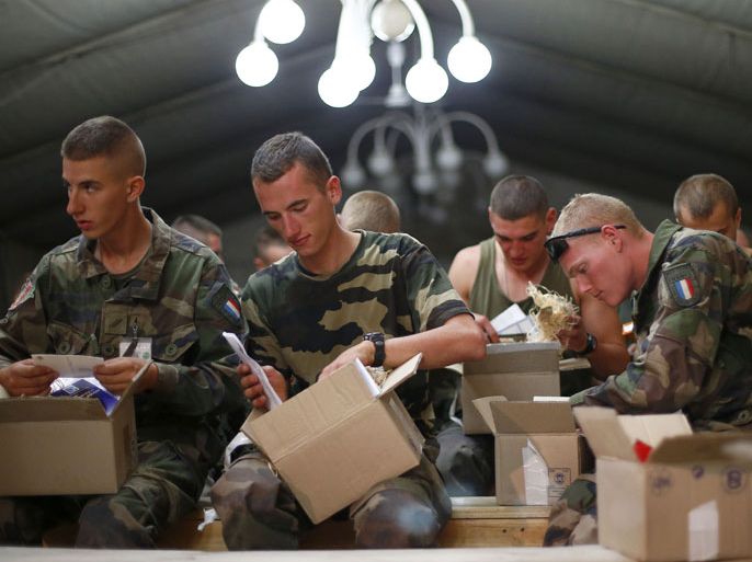 French soldiers from the 92eme Regiment d'Infanterie (92nd Infantry Battalion) of the French Army battlegroup Wild Geese open packages containing food and letters from children sent by a French association at Camp Warehouse in Kabul, on July 29, 2012. France is the fifth largest contributor to NATO's International Security Assistance Force (ISAF), which is due to pull out the vast majority of its 130,000 troops by the end of 2014. AFP PHOTO / ALEXANDER KLEIN