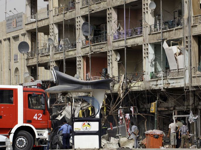 IRAQ : A fire engine arrives at the scene as Iraqi security gather following twin car bombs in the Karrada area of the capital Baghdad on July 31, 2012, killing 12 people and wounding at least 27 others