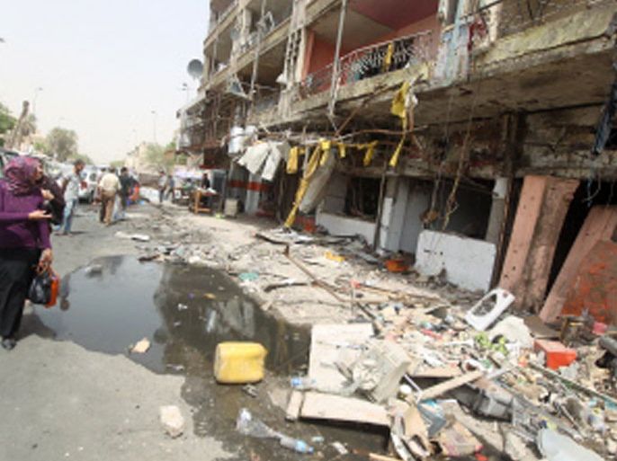 IRAQ : An Iraqi woman walks past destroyed shops on the ground floor of a building the day after twin car bombs in the Karrada area of the capital Baghdad on August 1, 2012, in which some 12 people were killed. July was the deadliest month in Iraq in almost two years, with 325 people killed in attacks, and included the deadliest day here since December 2009, official figures released showed. AFP PHOTO/AHMAD AL-RUBAYE