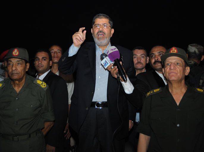 epa03357229 A Handout photograph released by the Egyptian Presidency on 10 August 2012, shows Egyptian President Mohamed Morsi (C) speaking to soldiers with the presence of Defense Minister Mohammed Hussein Tantawi (L) and armed forces Chief of Staff Sami Anan (R), during a Ramadan Iftar (breaking fast), near Al-Arish in Sinai, Egypt. Accoriding to media reports on 11 August, Egyptian military forces have arrested six militants suspected of involvement in a deadly weekend attack on border soldiers, as the army pursues a major crackdown in the Sinai Peninsula. EPA/EGYPTIAN PRESIDENCY/HANDOUT HANDOUT EDITORIAL USE ONLY/NO SALES