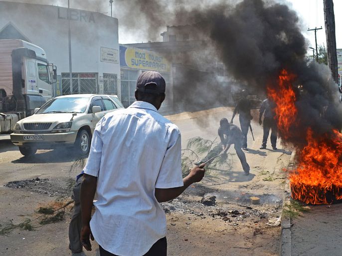 KENYA : Rioters burn tyres in Kenya's port city of Mombasa for a second day after the killing of an extremist cleric linked to Al-Qaeda-allied Shebab militants on August 28, 2012. Hundreds of angry youths have reportedly thrown stones, damaged cars after amassing in support of slain preacher Aboud Rogo Mohammed near the centre of Mombasa. The cleric, who was shot dead on August 27, 2012 by "unknown people", according to the police, was on US and UN sanctions lists for allegedly supporting the Shebab, including through recruitment and fundraising. He was driving with his wife and children when gunmen opened fire on his vehicle, leaving it riddled with bullets. AFP PHOTO/STRINGER