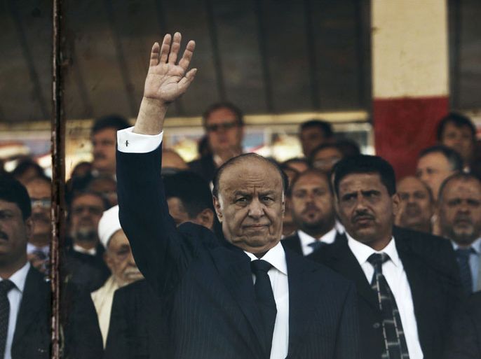 Yemen's President Abd-Rabbu Mansour Hadi waves from behind a bullet-proof glass shield as he watches a parade marking the 22nd anniversary of Yemen's reunification in Sanaa May 22, 2012. Yemeni soldiers marched in a National Day parade watched by the president from behind a bullet-proof glass shield on Tuesday, one day after a suicide bomber killed more than 90 of their colleagues in an attack on the rehearsal.