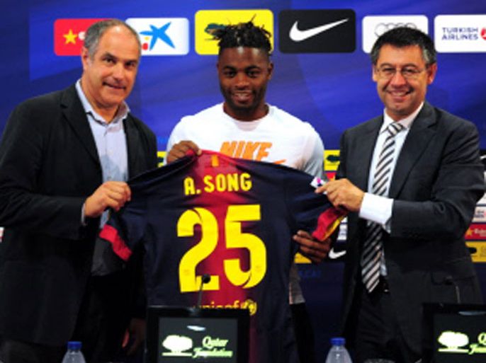 Barcelona new signing Cameroonian midfielder Alex Song (C) poses with former Spanish football player Andoni Zubizarreta (L) and Barcelona's deputy sporting director Josep Maria Bertomeu (R) on August 21, 2012 at the Camp Nou stadium in Barcelona. Song is the latest star player to leave the Emirates Stadium after Barcelona agreed to pay 15 million pounds (19 million euros) for Song, who will have a release clause of 80 million euros inserted in his contract. AFP PHOTO/LLUIS GENE.