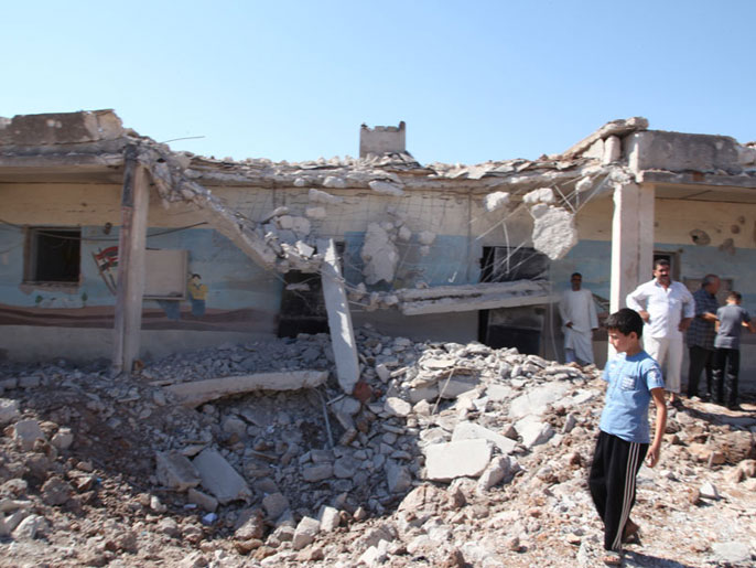 الأهالي يتفقدون الدمار في مدرسة بريف حلب بعد قصف الجيش النظامي(الجزيرة)