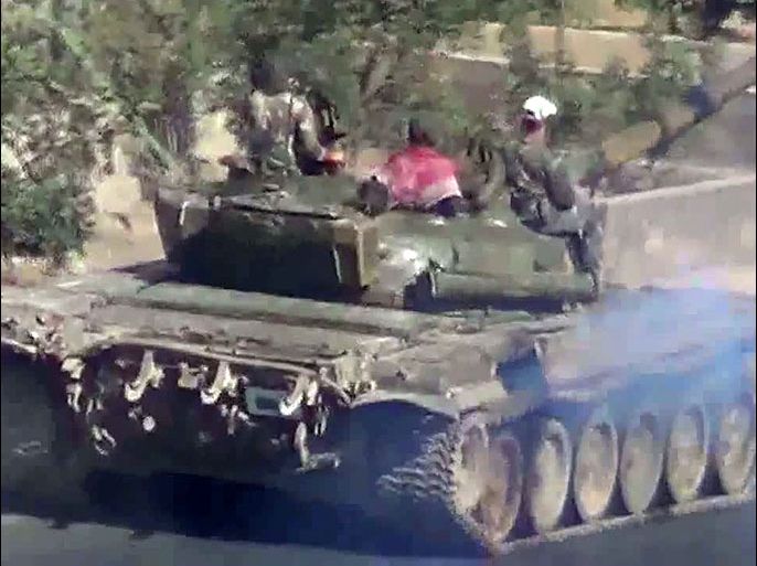 afp : An image grab taken from a video uploaded on YouTube on August 24, 2012 shows Syrian troops riding a tank on their way to Daraya on the outskirts of the capital Damascus. Several hundred bodies have been found in Daraya after a ferocious assault by the Syrian army, the Syrian Observatory for Human Rights on August 26, as activists accused government forces of a gruesome "massacre". AFP PHOTO/YOUTUBE