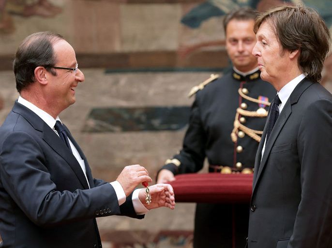 France's president Francois Hollande (L) awards former Beatles' singer Sir Paul Mc Cartney as officer of the "Legion d'Honneur" (Legion of honour), the French hightest award on September 8, 2012 at the Elysee Presidential Palace in Paris. AFP PHOTO / POOL PHILIPPE WOJAZER