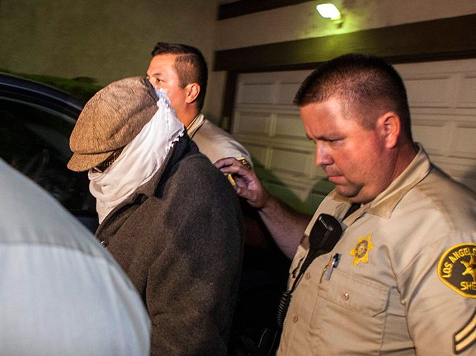 An unidentified person (L) is escorted out of Nakoula Basseley Nakoula's home by Los Angeles County Sheriff's officers in Cerritos, California September 15, 2012. Nakoula, a California man convicted of bank fraud is under investigation for possible probation violations stemming from the making of an anti-Islam video that has triggered violent protests against the U.S.in the Muslim world, U.S. officials said on Friday. The 55-year-old-man man told his Coptic Christian bishop that he was not involved in the film, but media reports have widely linked his name to the video. The obscure 13-minute English-language video, which was filmed in California and circulated on the Internet under several titles including "Innocence of Muslims," portrays Prophet Mohammad engaged in crude and offensive behavior. REUTERS