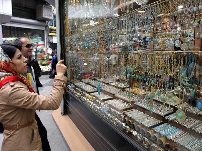 epa03144444 An Iranian couple window shopping in front of a jewelry shop in a bazaar in Tehran Iran, 14 March 2012. According to media reports, a lot of Iranians change their Rials into gold, as the Iranian currency lost almost half of his value against the US Dollar in the last three months due to economical sanctions imposed by the international community such as Europe and USA in relation with the Iranian nuclear program development. EPA/ABEDIN TAHERKENAREH