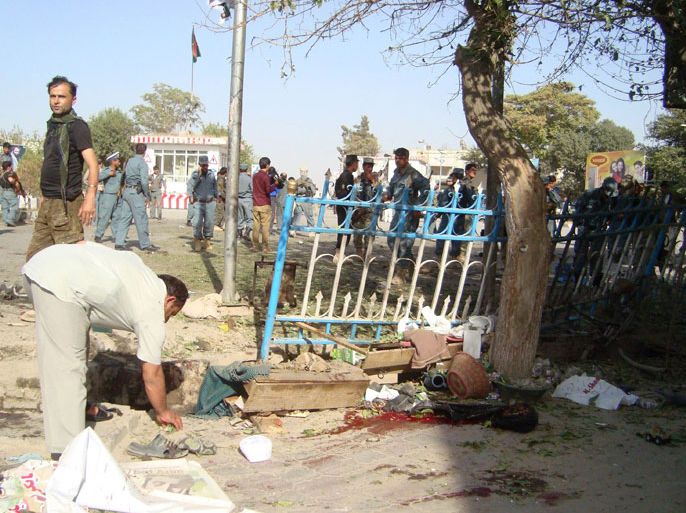 AFGHANISTAN : Police and investigators are pictured at the site of a suicide attack in Kunduz Province on September 10, 2012. A suicide bomber tore through a crowd of Afghan demonstrators on September 10, killing 21 people in the northern city of Kunduz, a hospital doctor said, amid fears that the toll could rise further