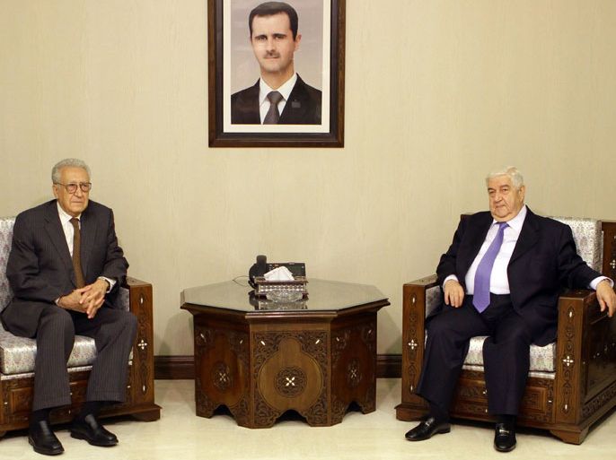 UN peace envoy Lakhdar Brahimi (L) meets with Syrian Foreign Minister Walid al-Muallem (R) in Damascus on September 13, 2012 as a portrait of President Bashar al-Assad is seen on the wall. Brahimi said on his first official visit to Damascus as UN and Arab League envoy that the conflict in Syria "is getting worse," the official SANA news agency reported. AFP PHOTO/LOUAI BESHARA