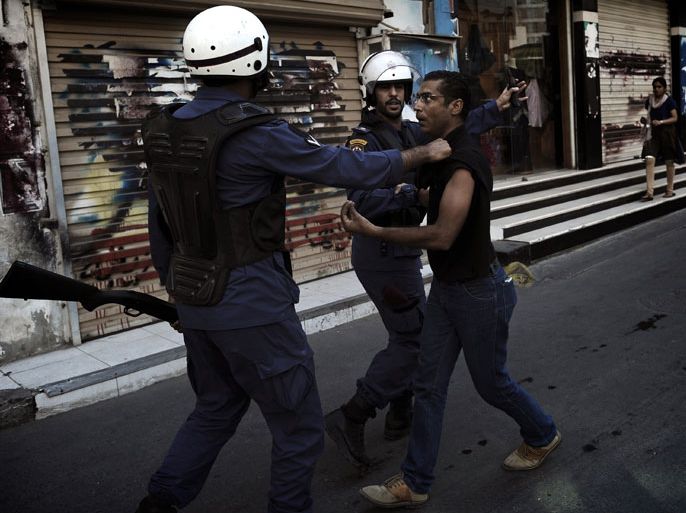 A Bahraini Shiite protester is detained by riot police during an anti-government demonstration in the centre of the capital Manama on September 21, 2012. AFP PHOTO/MOHAMMED AL-SHAIKH
