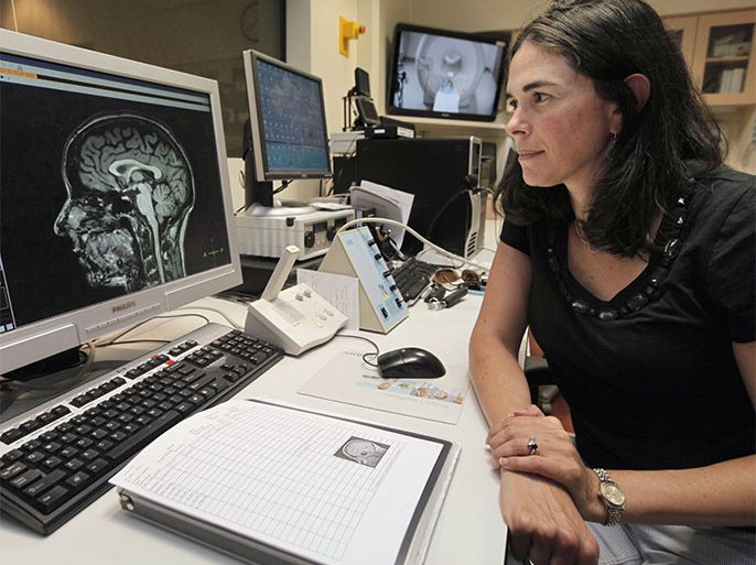In this Thursday, July 16, 2012 photo, Sian Beilock, a University of Chicago psychologist, professor and author of the book "Choke," looks at a brain scan from a functional MRI machine in the lab at the university in Chicago. Beilock studies the science behind "choking under pressure" and says the problem starts when players start worrying about the consequences of failure, what's on the line and what others will think of them. So when the big moment arrives, the athlete tries to take control by thinking about just exactly how to toss that basketball, make that putt or swing that racquet. "That's the worst thing you can do in the moment," Beilock said."What messes you up is not the worries but the overattention to detail.''.