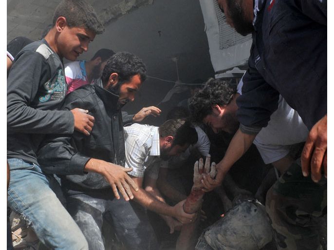 Syrian people pull the body of a victim from the rubble of a building destroyed following an airstrike by Syrian government forces in Maaret al-Numaan on October 18, 2012. Syrian regime warplanes launched a new wave of strikes on the northwestern town of Maaret al-Numan, seized by rebels last week, an AFP correspondent reported. AFP PHOTO/BULENT KILIC