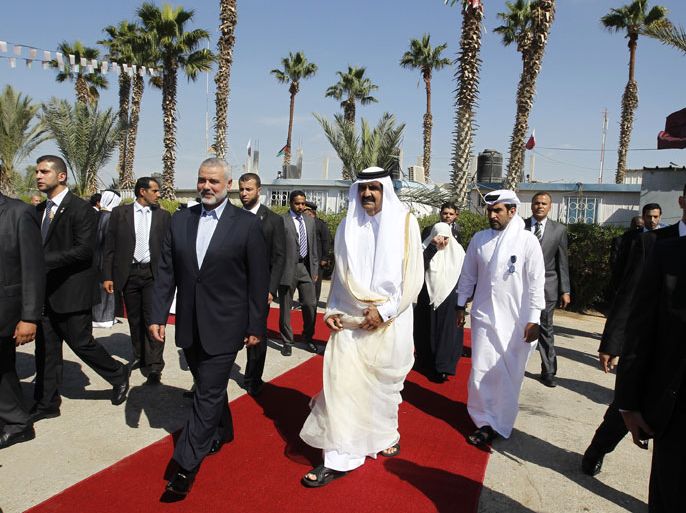 RAFAH, GAZA STRIP, - : Qatari Emir Sheikh Hamad bin Khalifa al-Thani (C-R) walks alongside Gaza's Hamas prime minister Ismail Haniyeh (C-L) during a welcome ceremony at the Rafah border crossing with Egypt on October 23, 2012 in the Gaza Strip. Sheikh Hamad bin Khalifa al-Thani arrived in the Gaza Strip in the first visit by a head of state since the Islamist Hamas movement took over in 2007. AFP PHOTO/MOHAMMED ABED