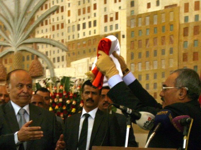 epa03124466 Newly elected Yemeni President Abdo Rabbo Mansour Hadi (L) receives the country's national flag from former president Ali Abdullah Saleh (R) during a ceremony at the presidential palace in Sana'a, Yemen, 27 February 2012. According to media reports, Yemen's newly-elected president Abdo Rabbo Mansour Hadi was officially inaugurated on 27 February, putting an end to the 33-year rule of former president Ali Abdullah Saleh. EPA/YAHYA ARHAB