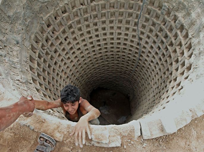 Palestinian man helps a smuggler to ascend a tunnel along the Gaza-Egypt border in Rafah, in the southern Gaza Strip on September 30, 2012. Since last month, Egyptian military have destroyed about 30 tunnels and blocked more which were used for smuggling to and from the Gaza Strip. The tunnels are a vital lifeline for supplies of food, clothes, building materials and fuel into the impoverished Palestinian territory subjected to an Israeli blockade since 2006