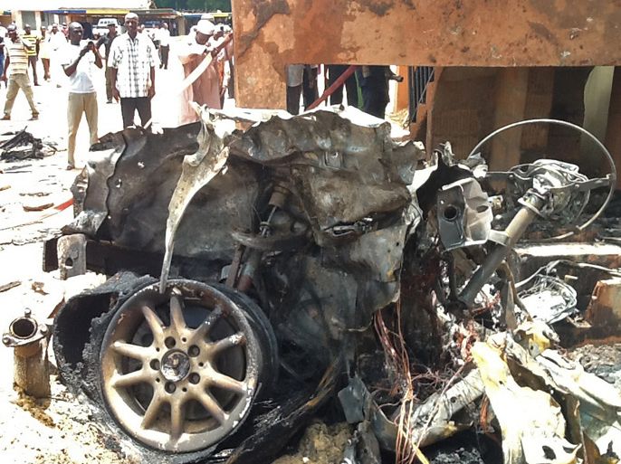 epa03327301 The remains of a car that was detonated in another car bomb attack in northern Nigeria is viewed by onlookers Sokoto Nigeria 30 July 2012. Two bombs killed at least two people in the historic seat of Islam in the north of Nigeria. EPA/STRINGER BEST QUALITY AVAILABLE