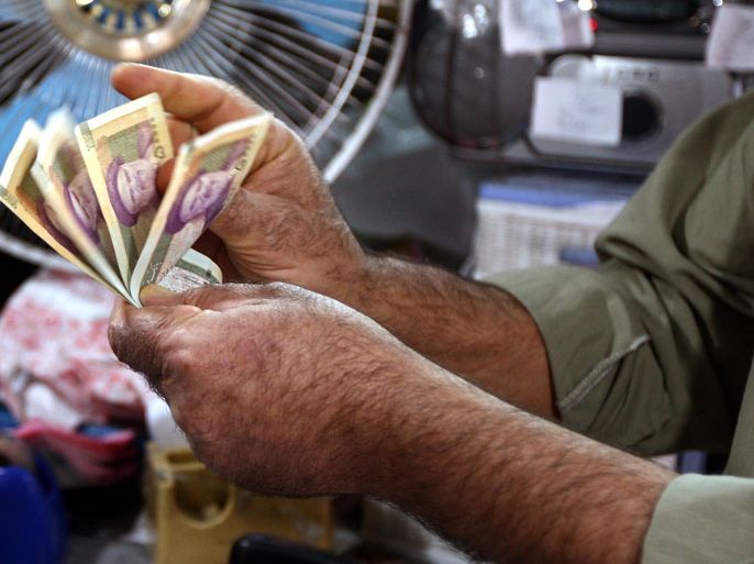 epa03419319 An Iranian man counts his rial 50,000 banknotes bearing a portrait of Iran's late founder of islamic Republic Ayatollah Khomeini, in a shop in Tehran, Iran, 03 October 2012. According to media reports, Iran's national currency, the Rial, crashed to a record low and deepened the already critical situation of the country's economy. 'The West has imposed sanctions on Iran and de facto started a hidden war against our people', Iranian President Ahmadinejad said on Monday 02 October during après conference EPA/ABEDIN TAHERKENAREH