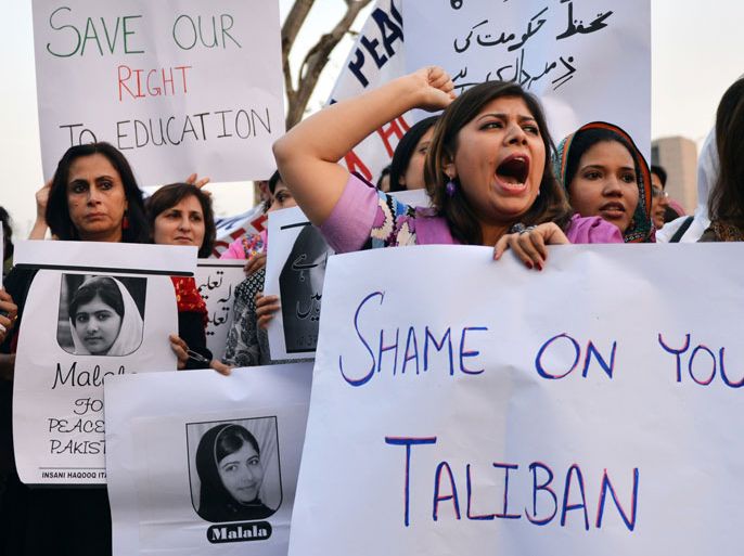 Pakistani civil society activists carry placards with a photograph of the gunshot victim Malala Yousafzai as they shout ant-Taliban slogans during a protest rally against the assassination attempt on Malala Yousafzai, in Islamabad on October 10, 2012. Pakistani doctors removed a bullet from a 14-year-old child campaigner shot by the Taliban in a horrific attack condemned by national leaders and rights activists