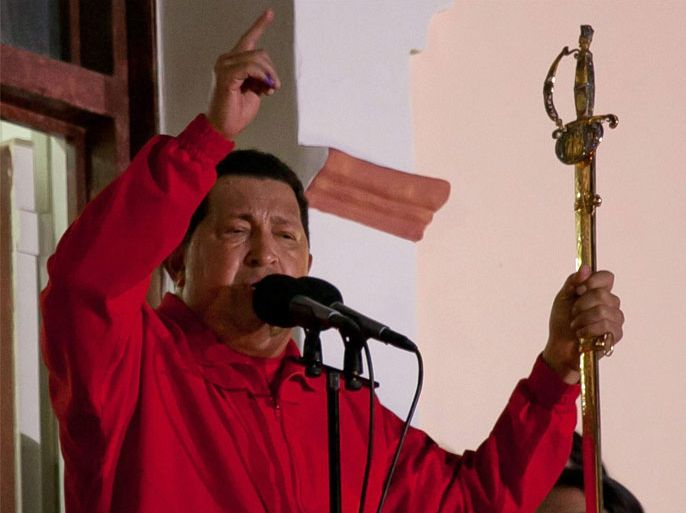 Venezuela President Hugo Chavez (L) holds Simon Bolivar's sword as he speaks from a balcony of the Miraflores presidential palace after winning Venezuelan presidential elections, in Caracas, Venezuela, late 07 October 2012. Venezuelan President Hugo Chavez was re-elected 07 October to a fourth term, which would bring his total years in office to 20, according to preliminary official results made public by the National Electoral Council. The left-wing populist Chavez received 54.42 per cent of the votes with about 90 per cent of the ballots counted while Henrique Capriles, the unified opposition candidate, received 44.97 per cent. The results would secure Chavez, 58, another six-year mandate, taking his term of office through 2019.