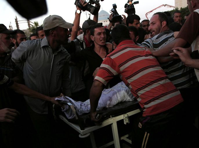 Palestinians wheel the body of militant Ahmad Fatayer into Al-Aqsa hospital in Deir al-Balah in the central Gaza Strip after he was killed in an Israeli air strike on October 14, 2012. Two Gazans died in an Israeli strike, raising to five the total number killed as Israel pressed a series of raids targeting militants, among them a top Salafist leader. AFP PHOTO/SAID KHATIB
