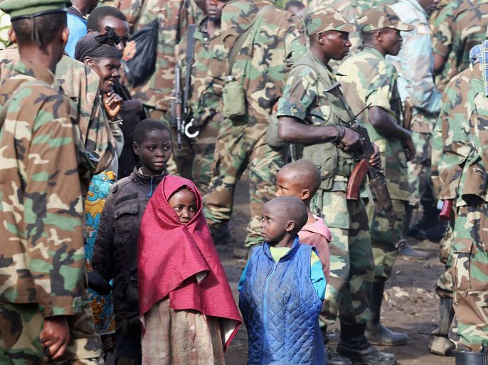 Children look at M23 rebel fighters as they prepare for withdrawal from Karuba, some 62 km west of Goma November 28, 2012. Rebels in the Democratic Republic of Congo said on Tuesday they would pull out of the eastern city of Goma in an apparent stalling of their drive to "liberate" the whole country. REUTERS