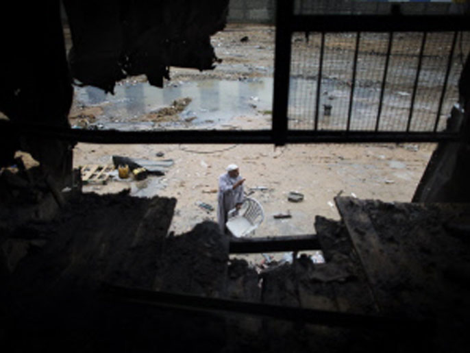 ‪‬ فجوة في جدار مصنع بلاستيك أحدثها قصف إسرائيلي لغزة(الفرنسية)