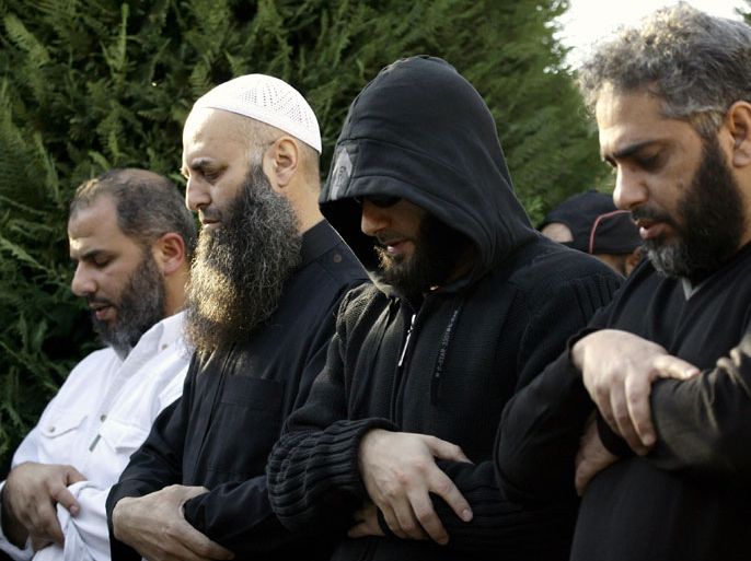 Sidon, -, LEBANON : Sunni Salafi Sheikh Ahmed al-Assir (2 L) and Singer Fadel Shaker (R) pray during a funeral in the southern Lebanese port city of Sidon, on November 12, 2012. Three people were killed in Sidon in a gunbattle between supporters of the Shiite group Hezbollah and a hardline Sunni cleric, a security official said. AFP PHOTO / MAHMOUD ZAYYAT