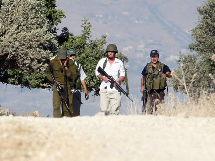 Israeli soldiers with a Jewish settler from the settlement of Itmar carry their guns during clashes with Palestinians after four Palestinians were allegedly attacked by Jewish settlers near the West Bank city of Nablus on 07 July 2012. EPA/ALAA BADARNEH