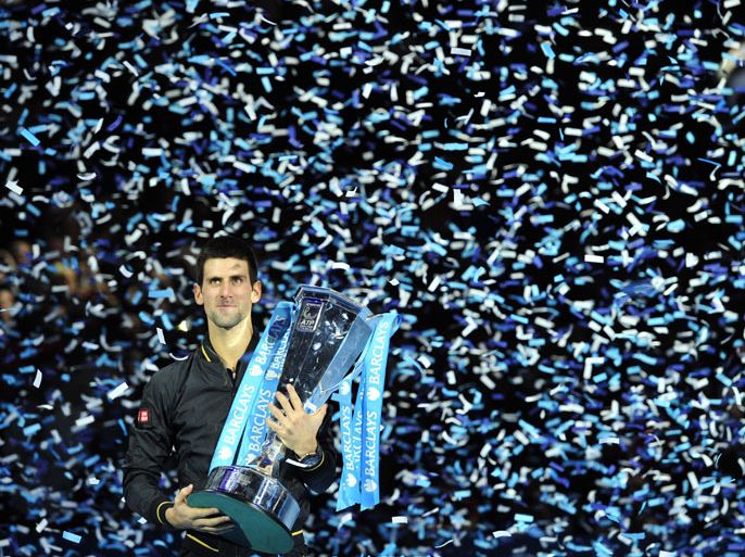 Serbia's Novak Djokovic poses with the winners' trophy after the singles final against Switzerland's Roger Federer on the eighth day of the ATP World Tour Finals tennis tournament in London on November 12, 2012. AFP PHOTO / GLYN KIRK