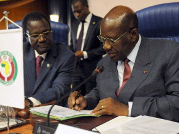 President of ECOWAS Commission Kadre Desire Ouedraogo (L) watches Chairman of the Mediation and Security Council Daniel Duncan sign a document during the opening session of ECOWAS Mediation and Security Council in Abuja on November 9, 2012. West African nations on Friday plotted military force against "terrorist groups" in Islamist-occupied northern Mali as regional foreign and defence ministers met on a strategy to win back the vast territory. AFP PHOTO/PIUS UTOMI EKPEI