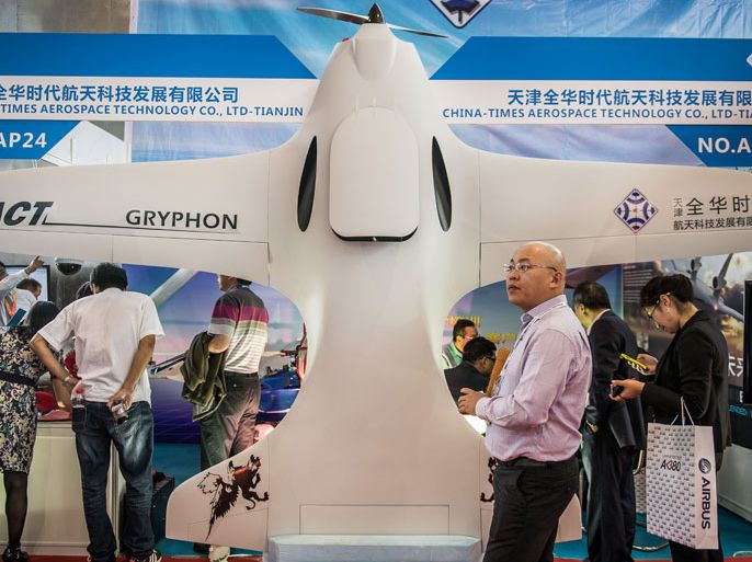 A man looks on next to a Chinese made drone displayed during the 9th China International Aviation and Aerospace Exhibition in Zhuhai on November 13, 2012. China's air show comes as the Communist Party holds a meeting to select the country's new leaders -- including the party's Central Military Commission, which controls the armed forces. AFP PHOTO / Philippe Lopez